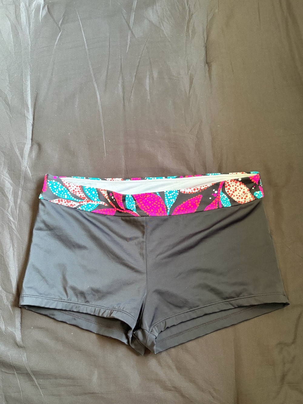 South Point black swim shorts w/multicolored leaf pattern on waistband. Size 14.